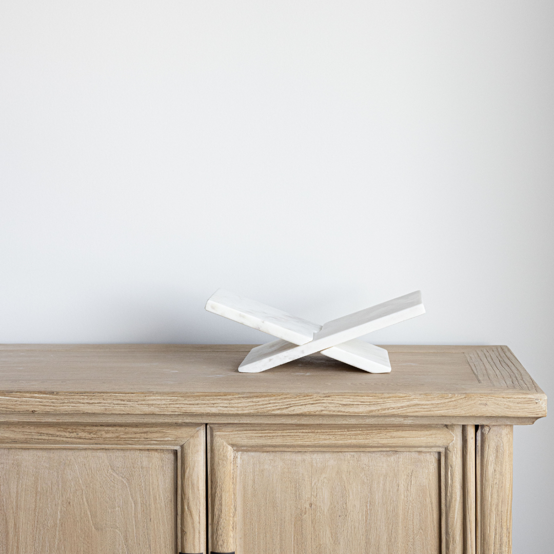 Marble book stand on a wooden surface with a plain background