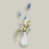 Vase of dried floral arrangement made with delicate, lace-like petals of white Cape Flowers against the intriguing, sculpted heads of blue Teasels. Adding airy lightness and enduring colour is German Statice. 