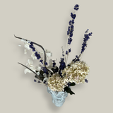 Top view of a decorative everlasting flower arrangement in a concrete vase sculpted as a woman's serene face with her lips charmingly puckered