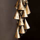 Decorative hanging brass bells on a dark background