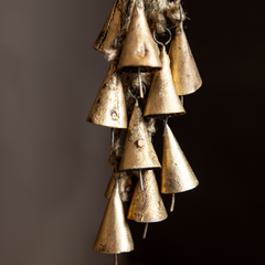 Decorative hanging brass bells on a dark background