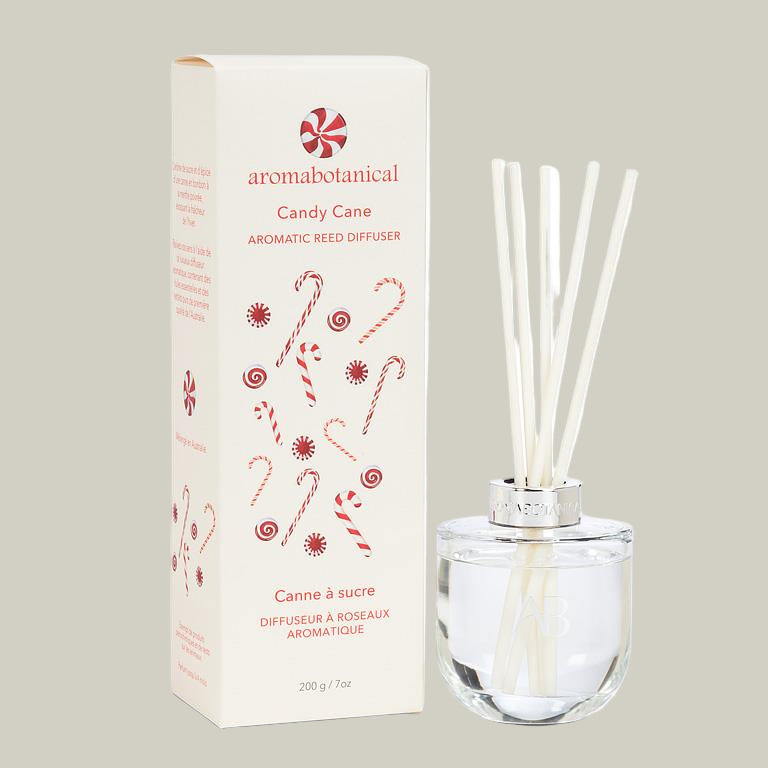 Aromatherapy diffuser with reeds and packaging featuring candy cane design on a white background