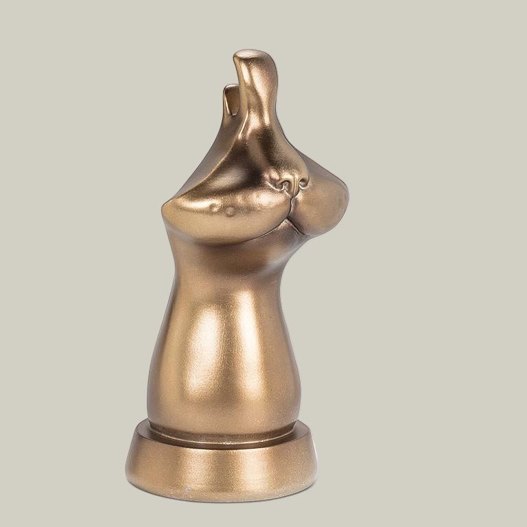 The side view of bronze coloured eye glass holder that is shaped like the lower portion of a cat's face.