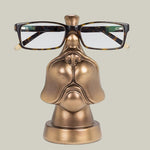 Bronze coloured eye glass holder that is shaped like the lower portion of a dog's face.