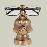 Bronze coloured eye glass holder that is shaped like the lower portion of a dog's face.