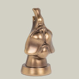 The side view bronze coloured eye glass holder that is shaped like the lower portion of a dog's face.