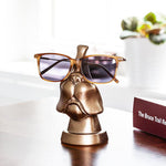 Bronze coloured eye glass holder that is shaper like the lower portion of a dog's face.