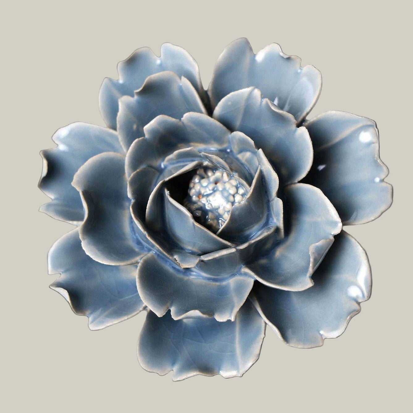 Beautiful Azure ceramic Peony sculpture on a soft green background.