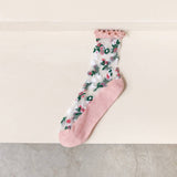 Sheer floral socks with light pink ruffle top and sole on a light background
