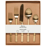 Gold plated stainless steel flatware set with in it's packaging, a tan coloured box with a white band