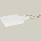 White marble cutting board with a rope handle on a white background