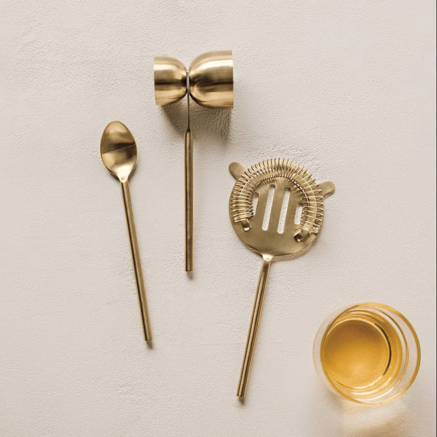 Our Gilded Bar Tool set featuring a beautiful matte gold finish cocktail strainer, mixing spoon and dual sized measuring tool