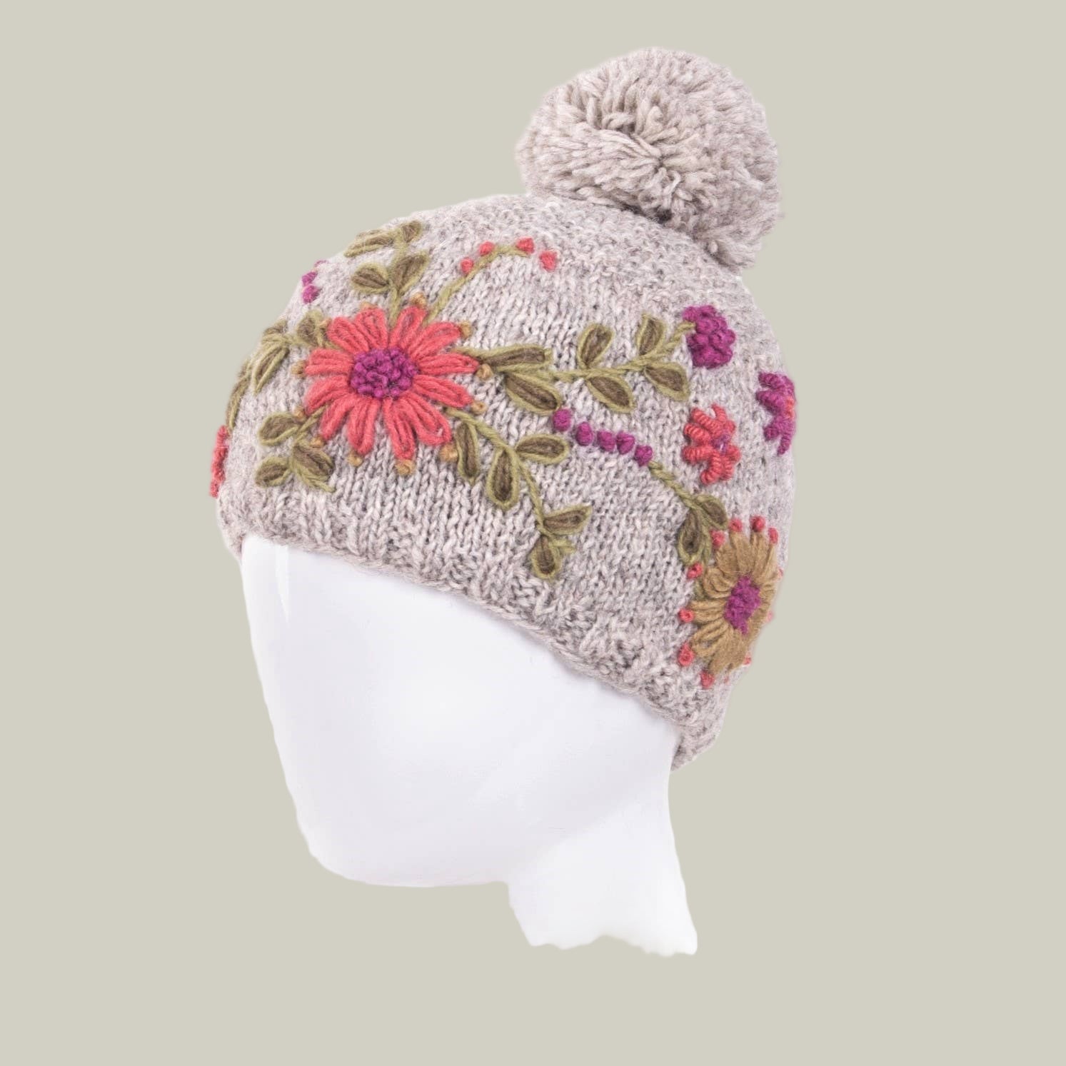 Knitted hat with floral patterns and a pom-pom