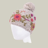 Knitted hat with floral patterns and a pom-pom