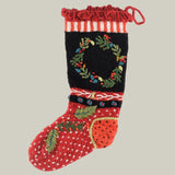 Hand-knit, Christmas stocking with hand-embroidered wreath on a deep black knit background, accented by bright berry clusters and holly leaves.