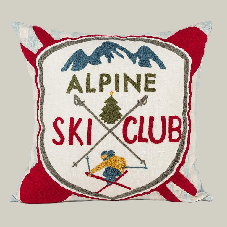 Decorative pillow with 'Alpine Ski Club' design featuring mountains, skiers, and trees.