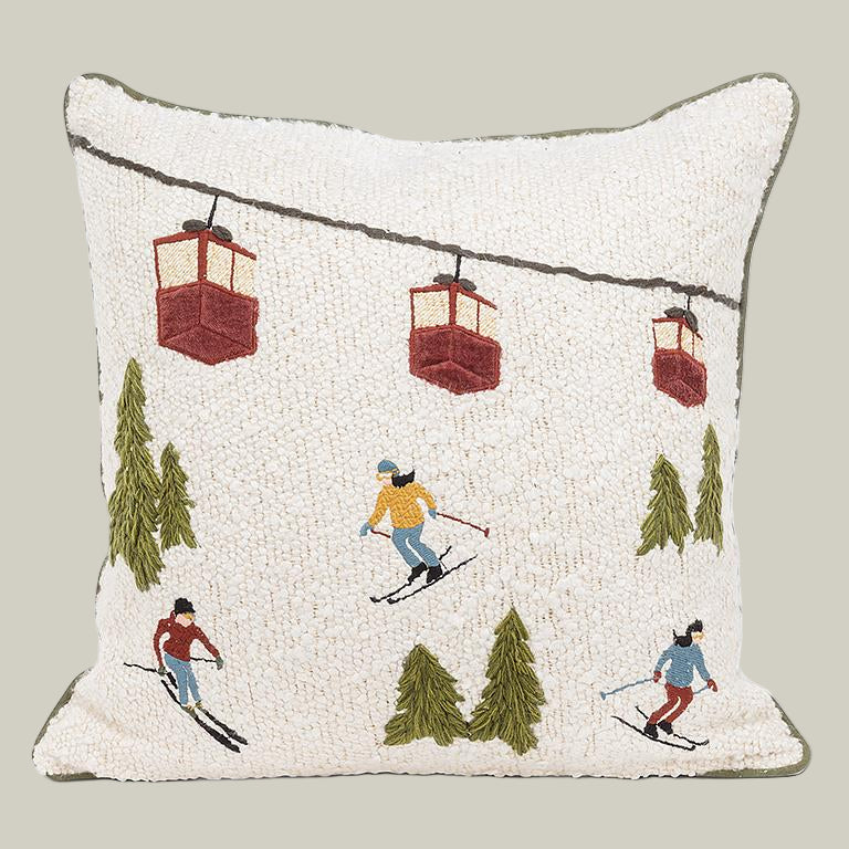 Decorative pillow with skiing and cable car design on a white background