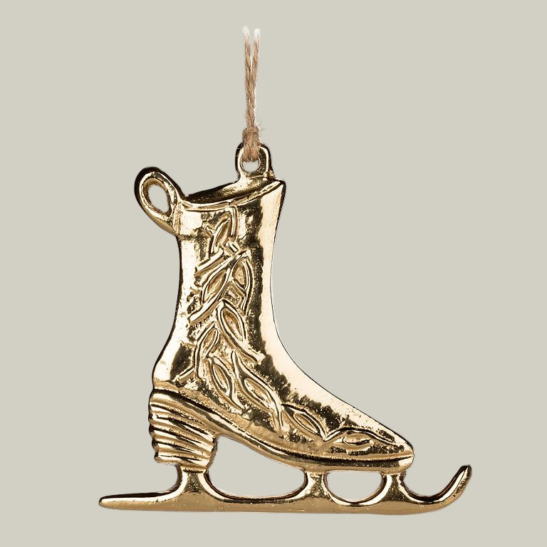 Gold ice skate ornament on a white background