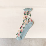 Sheer floral socks with light blue ruffle top and sole on a light background