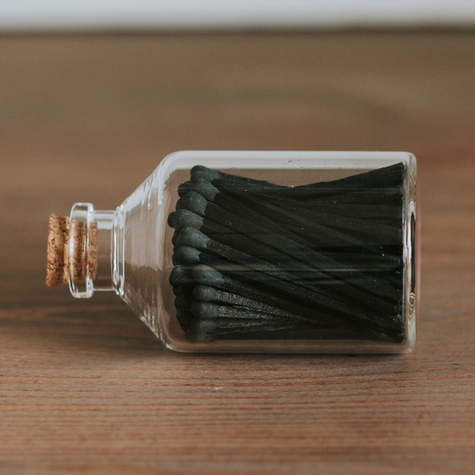Glass bottle with matches on a wooden surface