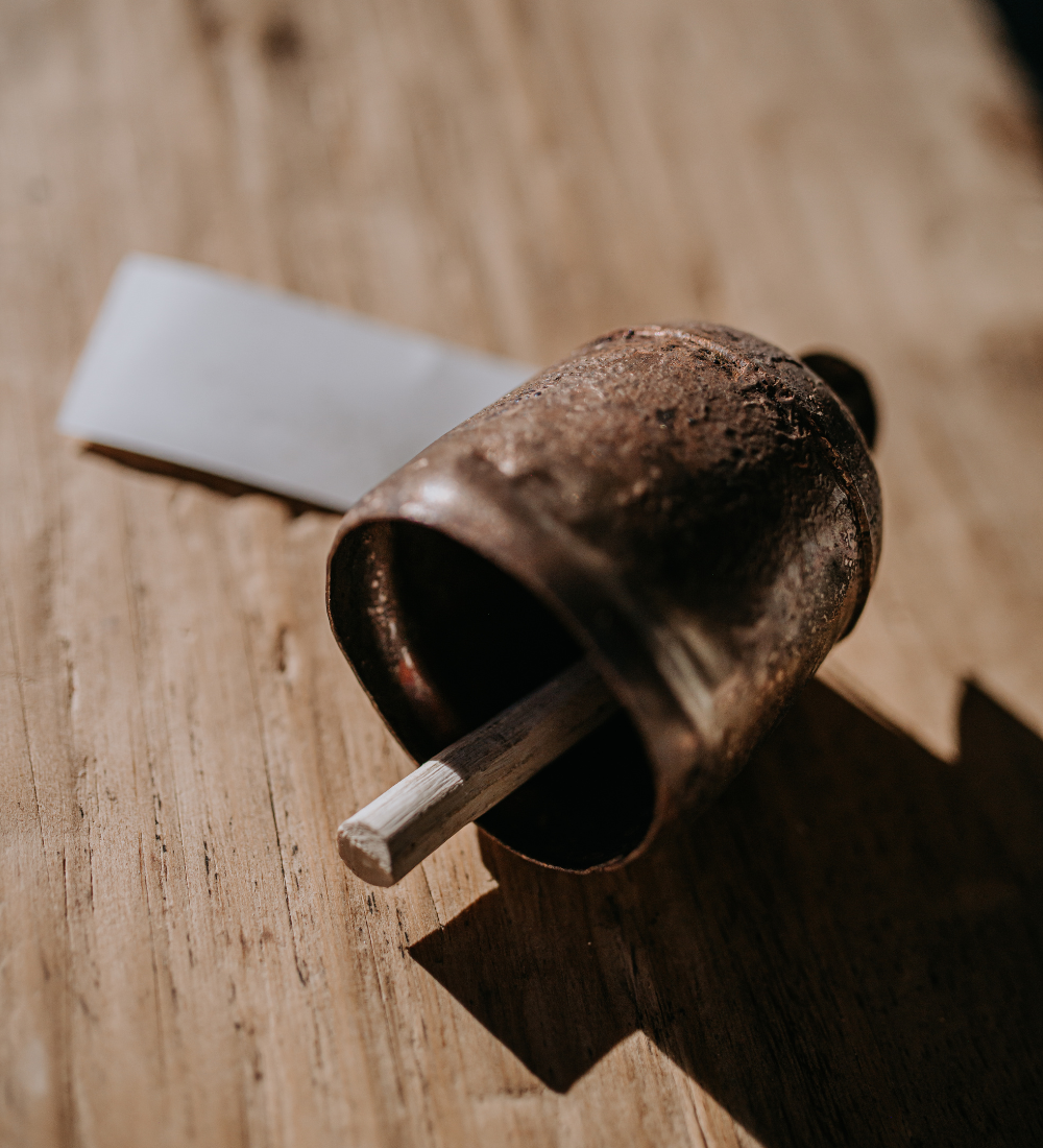 Copper-colored bell on a wooden surface