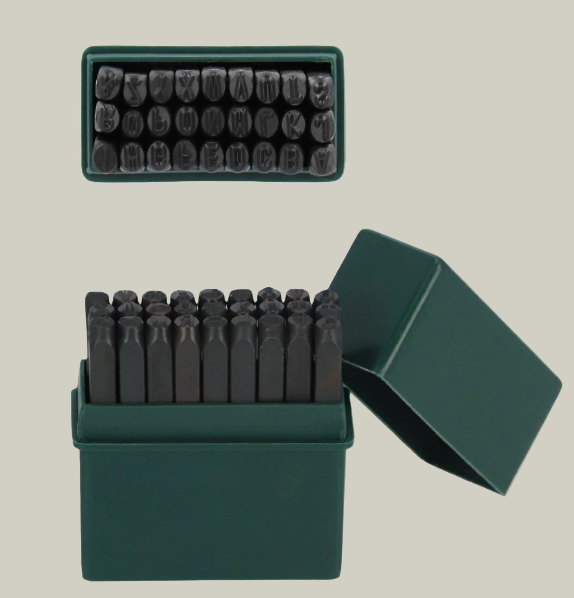 Set of metal stamps in a green box on a light green background