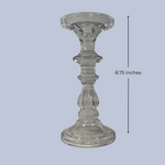 Clear glass candle holder with measurement label on a light gray background