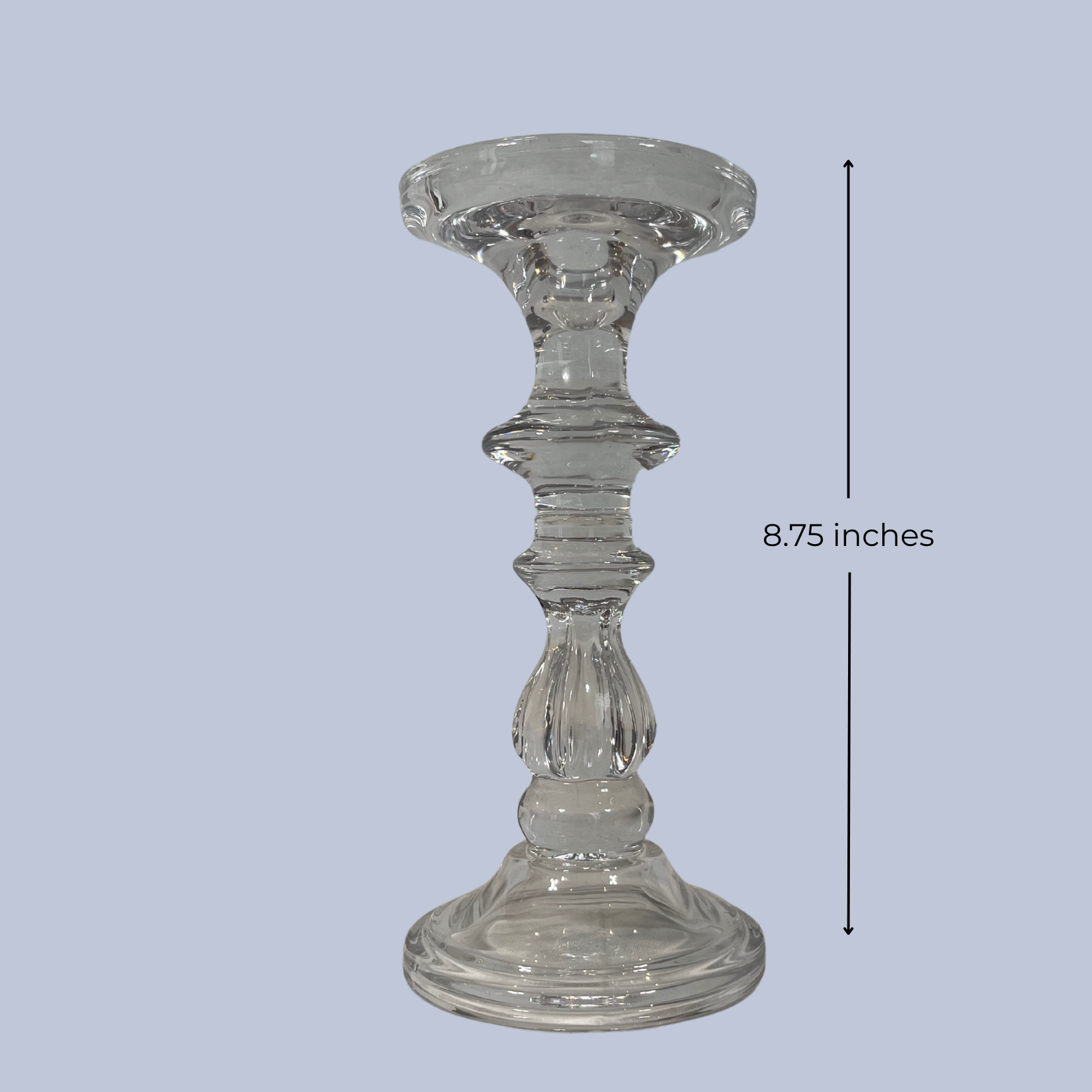 Clear glass candle holder with measurement label on a light gray background