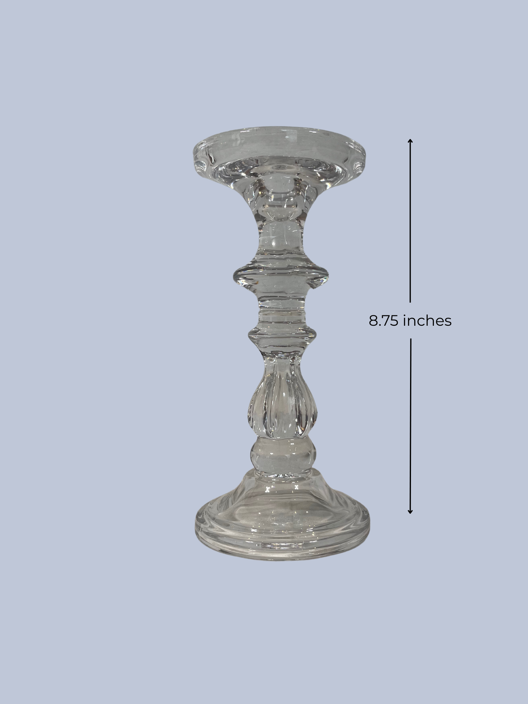 Clear glass candle holder with measurement label on a light gray background