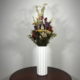 This magnificent, hand-tied bouquet is a vibrant symphony of contrasting colours and textures designed for the sophisticated interior. Seen here in a vibrant white ceramic vase. 