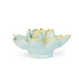 A ceramic water lily shaped sculpture  with a light blue glaze and pale yellow accents on the petals, set against a plain white background.