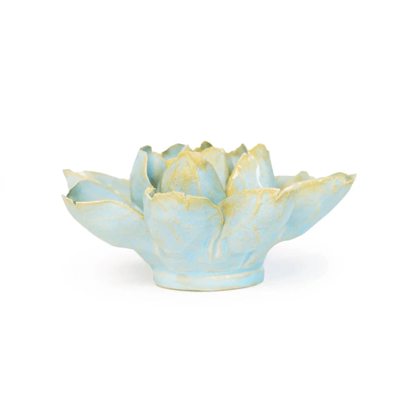 A ceramic water lily shaped sculpture  with a light blue glaze and pale yellow accents on the petals, set against a plain white background.