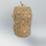 Decorative candle embossed with sunflowers with a light grey background