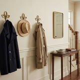 Entryway with coat, hat, and umbrella hanging on hooks, a mirror, and a small table.