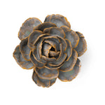 A ceramic English Rose sculpture with layered petals in muted gray-blue and warm bronze-brown tones, photographed from above on a plain white background.