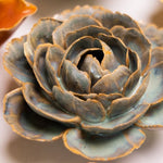 Close-up of ceramic flowers in various colors on a light background