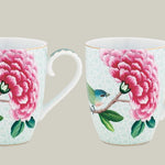 Two ceramic mugs with floral and bird design on a white background