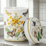 Decorative bone china canister with butterfly and floral design on a white surface.