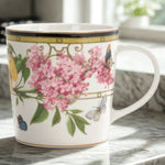 Decorative mug with floral and butterfly design on a marble surface