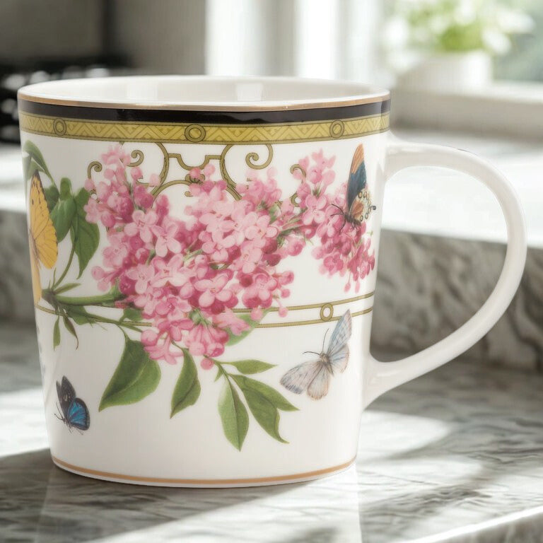 Decorative mug with floral and butterfly design on a marble surface