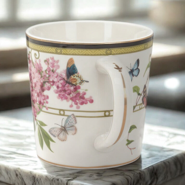 Decorative mug with floral and butterfly design on a marble surface
