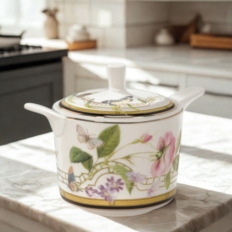 Decorative sugar bowl and lid with floral and butterfly design on a kitchen counter