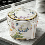 Decorative teapot with floral and butterfly design on a marble surface