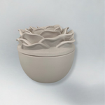 Decorative candle in container with floral designed lid