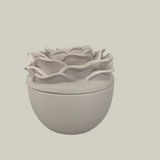 Decorative candle in container with floral designed lid