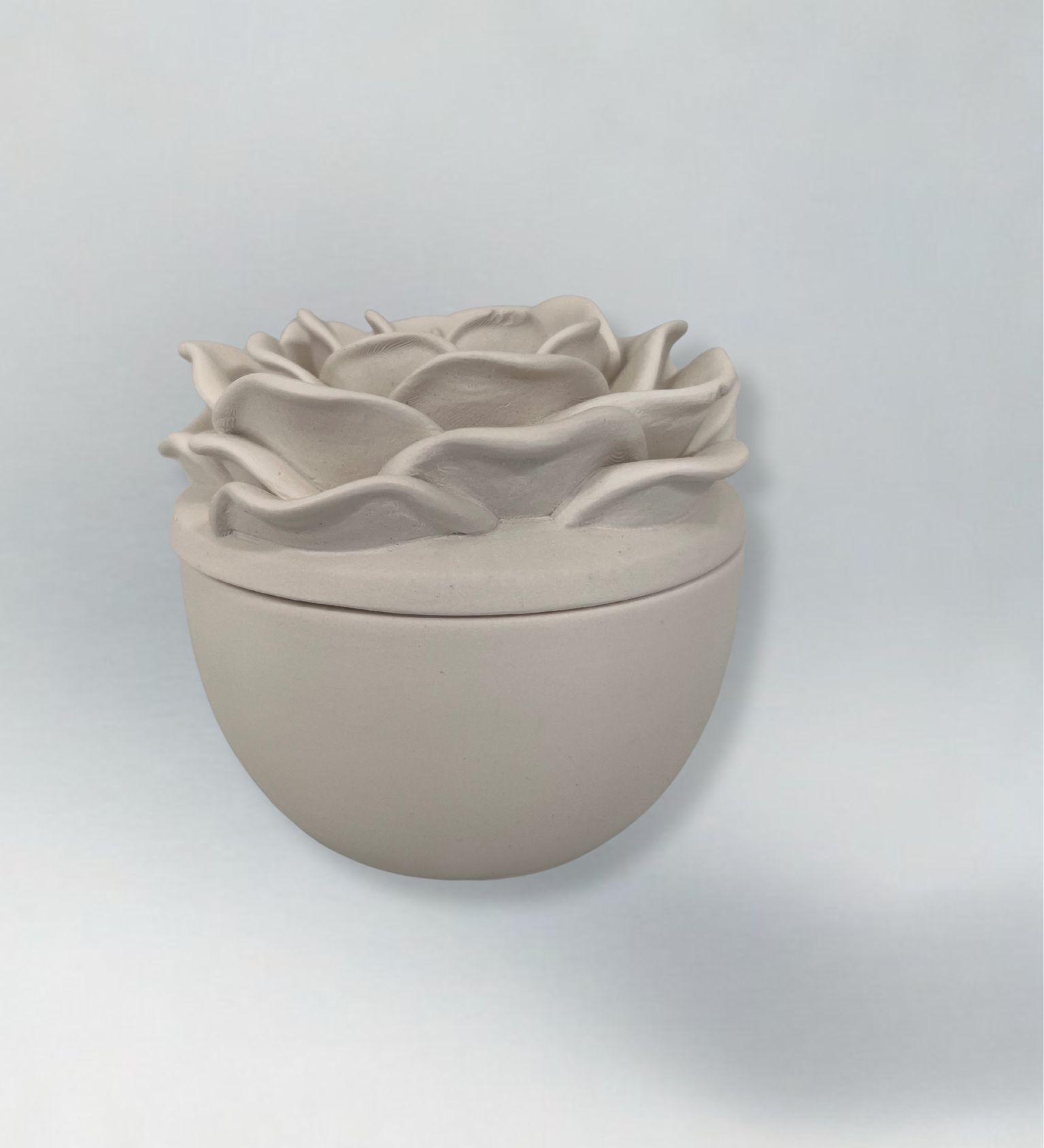 Decorative candle in container with floral designed lid