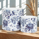 Two ceramic planters with blue floral patterns on a wooden surface.