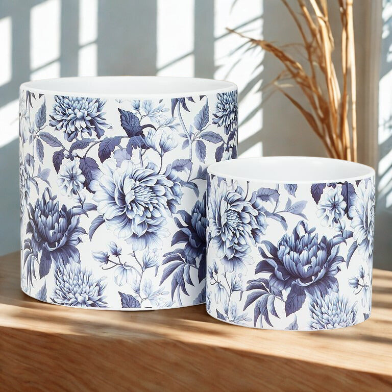 Two ceramic planters with blue floral patterns on a wooden surface.
