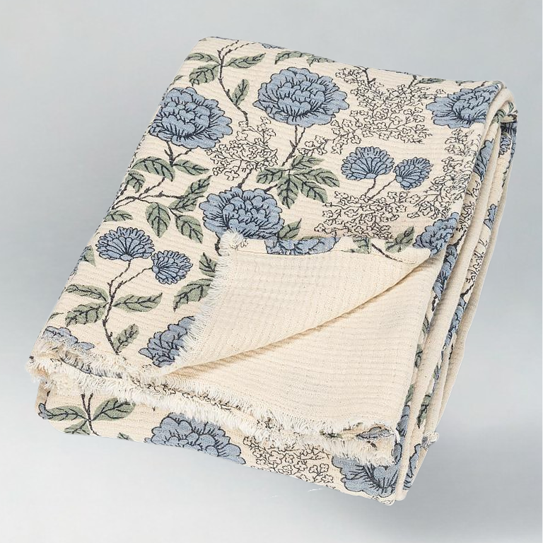 Floral patterned quilt with blue flowers on a ivory background