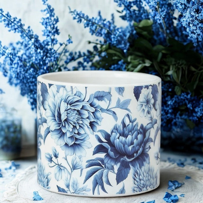 Ceramic planter with blue floral pattern against a blurred floral background